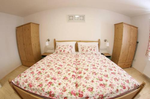 1 dormitorio con 1 cama con colcha de flores en Penzion U Zamku, en Jaroměřice na Rokytné