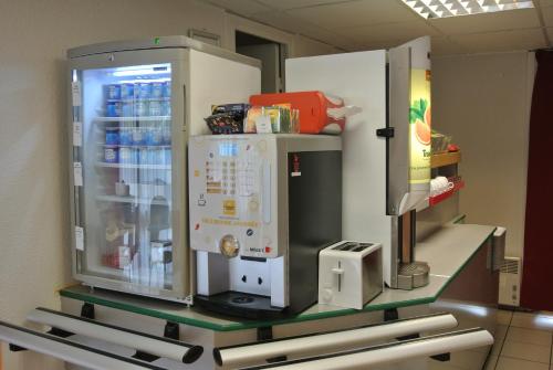 a large refrigerator with a drink inside of it at Premiere Classe Lyon Sud - Chasse Sur Rhône in Chasse-sur-Rhône