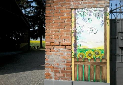 a brick wall with a painting of sunflowers on it at La Cortevecchia in Lobbi