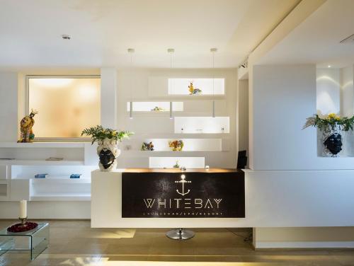 a whitebey store with a sign on a counter at White Bay in Fontane Bianche