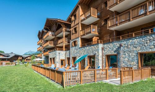 - un bâtiment avec balcon et cour dans l'établissement CGH Résidence Boutique Les Chalets De Laÿssia, à Samoëns
