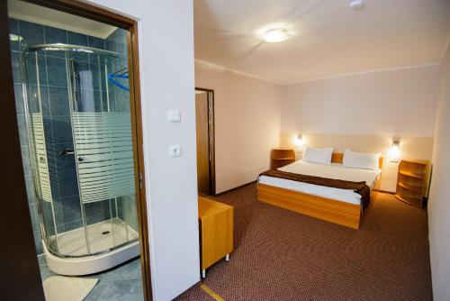 a hotel room with a bed and a shower at Residence Piata Sfatului in Braşov