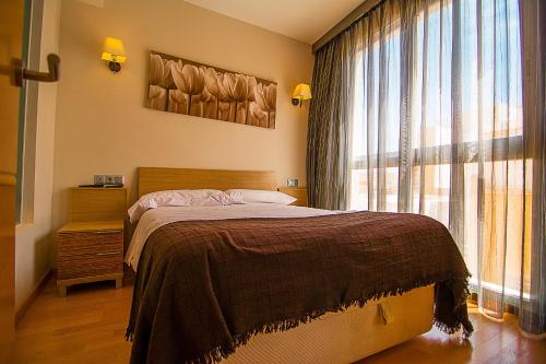 a bedroom with a bed and a large window at Dream Suites & Apartaments Almería in Almería
