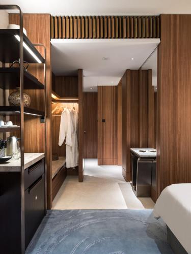 a bedroom with wooden walls and a bed and a closet at Kerry Hotel Hong Kong by Shangri-la in Hong Kong