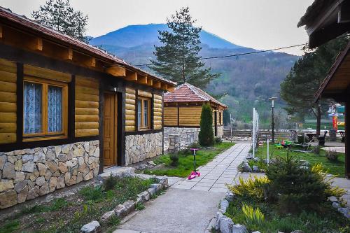 a house with a stone wall next to a building at Antik in Foča