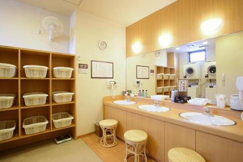 a bathroom with two sinks and a large mirror at Hotel Route-Inn Fujieda-Eki Kita in Fujieda