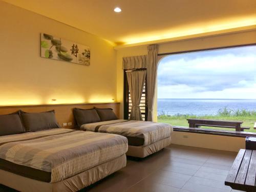 a hotel room with two beds and a large window at White Sand Beach 32 in Green Island