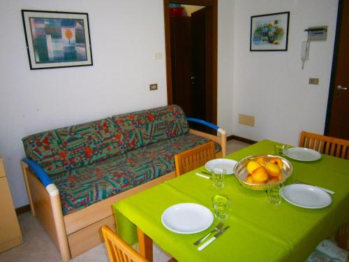 a living room with a green table and a couch at Residence Soleil - Agenzia Cocal in Caorle