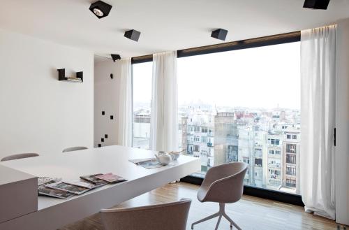 バルセロナにあるDestinationBCN Urgell Apartmentの白いダイニングルーム(大きな窓付)