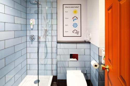 uma casa de banho com 2 lavatórios e uma cabina de duche em vidro. em ibis Styles Manchester Portland em Manchester