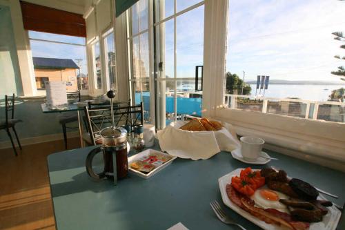 una mesa con un plato de comida y un desayuno de huevos en Freycinet Waters en Swansea