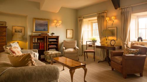 a living room with a couch and chairs and a table at Priory Wareham in Wareham
