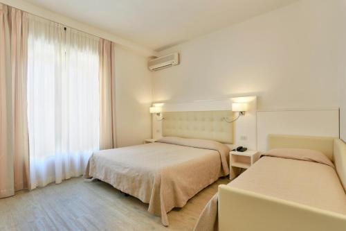 a hotel room with two beds and a window at Hotel Lupori in Viareggio