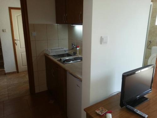 a small kitchen with a sink and a television at Apartments Montenegro Risan Čučković in Risan