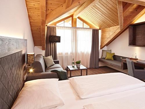 a bedroom with a bed and a living room at Hotel Die Krone - Immenstadt-Stein in Immenstadt im Allgäu