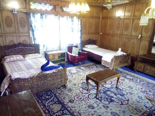 a bedroom with two beds and a table and a chair at Kashmir View group of Houseboat in Srinagar