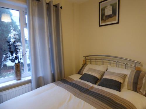 a bedroom with a bed with two pillows and a window at Birdholme House in Chesterfield