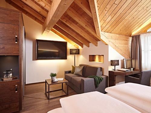 a hotel room with a couch and a tv at Hotel Die Krone - Immenstadt-Stein in Immenstadt im Allgäu