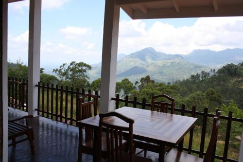 a table and chairs on a balcony with a view of mountains at Ella Repose in Ella