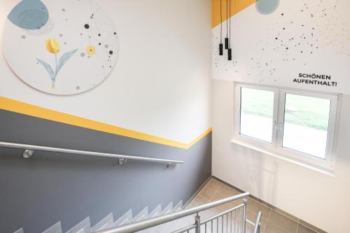 a staircase in a building with a clock on the wall at Hotel Tullnerfeld in Tulln