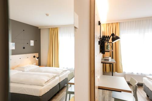 ein Hotelzimmer mit 2 Betten und einem Tisch in der Unterkunft Hotel Tullnerfeld in Tulln