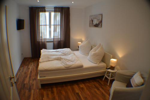 a bedroom with a bed with white sheets and a window at Apartment Avenzio in Würzburg