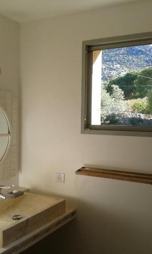 a bathroom with a sink and a window at Maison 2 chambres et piscine chauffée entre L'Ile Rousse et Monticello in Monticello