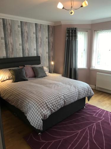 1 dormitorio con cama y alfombra morada en Hillford House, en Stirling