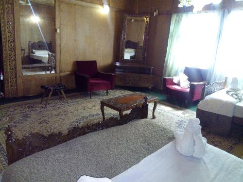 a bedroom with a bed and a living room at Kashmir View group of Houseboat in Srinagar
