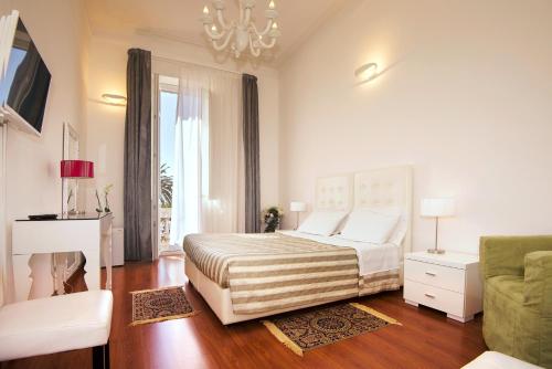 una camera bianca con un letto e un divano di Blanco Rooms a Cagliari