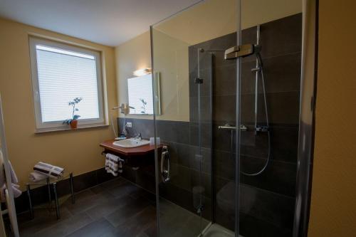 a bathroom with a shower and a sink at Hotel Garni Zur Alten Post in Lembruch