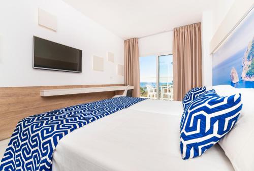 a bedroom with a large bed with a tv on the wall at Globales Palmanova in Palmanova