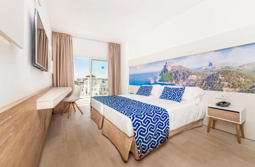 um quarto de hotel com uma cama e uma grande janela em Globales Palmanova em Palmanova