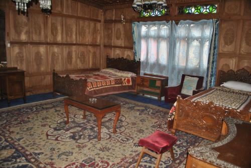 a bedroom with two beds and a table and chairs at Kashmir View group of Houseboat in Srinagar