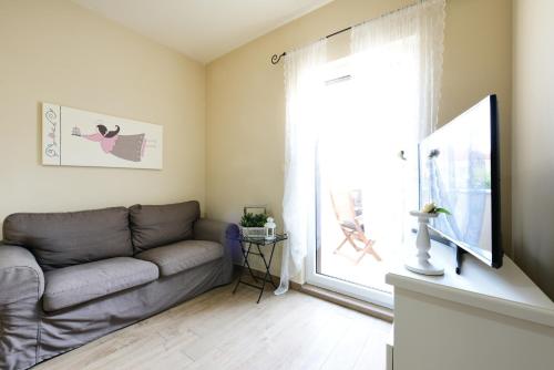 uma sala de estar com um sofá e uma grande janela em Apartments ZARA & TONI em Zadar