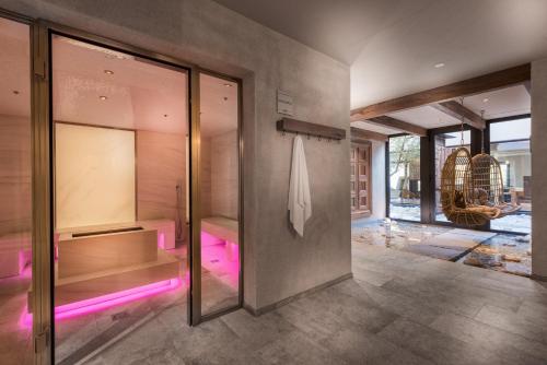 une salle de bains avec des lumières roses sur le mur dans l'établissement Das Paradies, à Laces