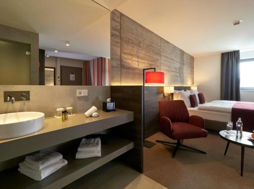 a bathroom with a tub and a sink and a bed at Hostellerie Stafelter in Walferdange