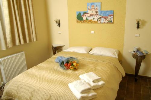 a bed with towels and a bowl of flowers on it at Filoxenia Studios in Galaxidi