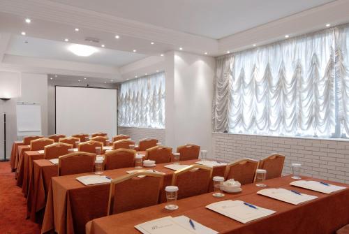 a conference room with tables and chairs and a large window at Athens Atrium Hotel & Jacuzzi Suites in Athens