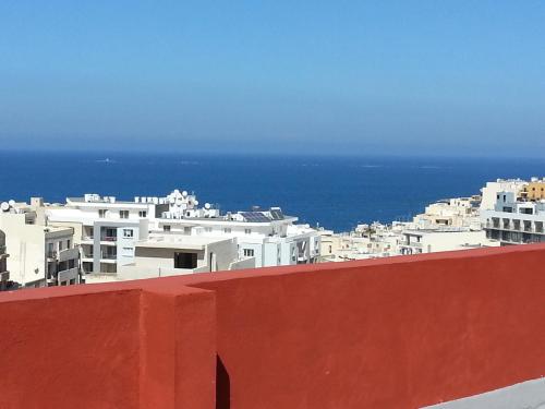 a view of a city with white buildings and the ocean at For Rest Aparthotel in St Paul's Bay