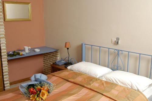 a bedroom with a bed with a bowl of flowers on it at Filoxenia Studios in Galaxidi