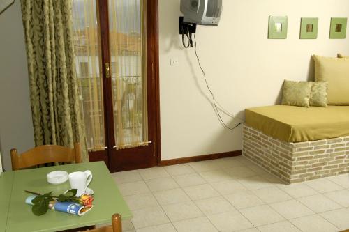 a living room with a table and a bed and a television at Filoxenia Studios in Galaxidi