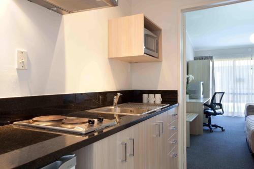 a kitchen with a sink and a counter top at Auckland Airport Kiwi Motel in Auckland