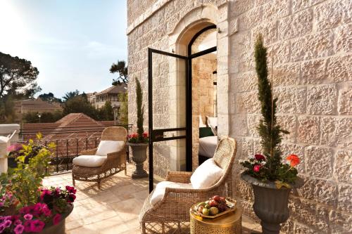 a patio with chairs and flowers on a brick wall at Villa Brown Jerusalem, a member of Brown Hotels in Jerusalem