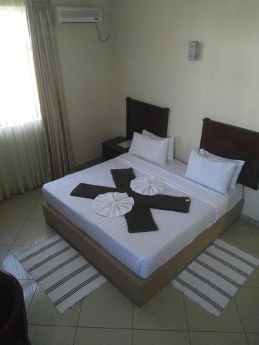 a bedroom with a large bed with black crosses on it at Pensao Marhaba Residencial in Maputo