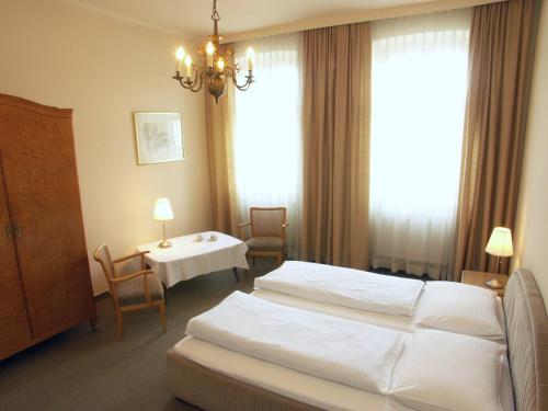 una camera d'albergo con due letti e un tavolo con sedie di AMSEL VINTAGE Rooms a Vienna