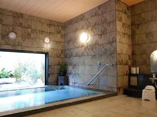 a swimming pool in a room with a tile wall at Hotel Route-Inn Nabari in Nabari