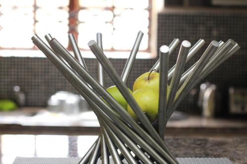 Eine mit Äpfeln gefüllte Vase steht auf einer Küchentheke. in der Unterkunft Guesthouse@Mbalistar in Queenstown