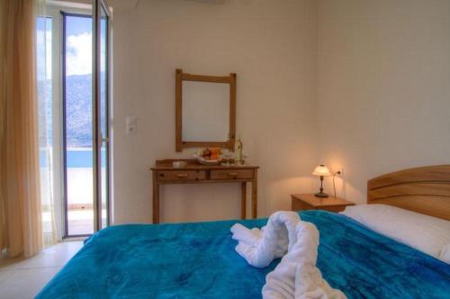 a bedroom with a blue bed with a mirror at Psaropoula in Balíon