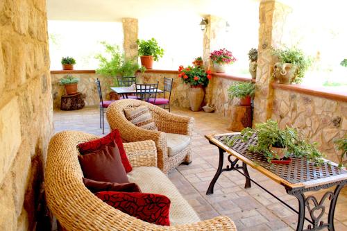 an outdoor patio with wicker chairs and a table at Casale Orioles in Torretta